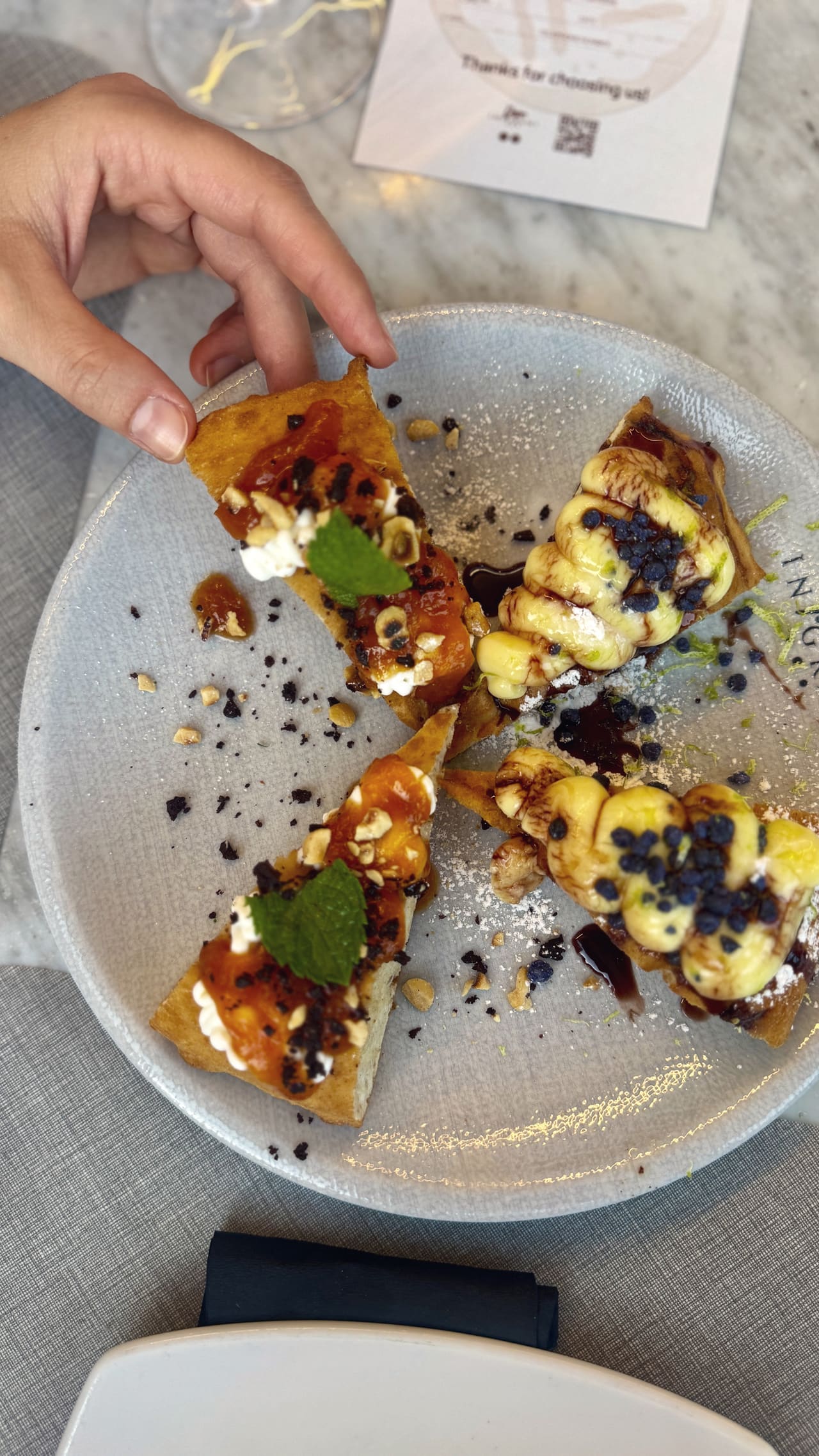 A dessert of fried dough in quarters — apricot with hazelnut and mint on two, custard and chocolate on the others