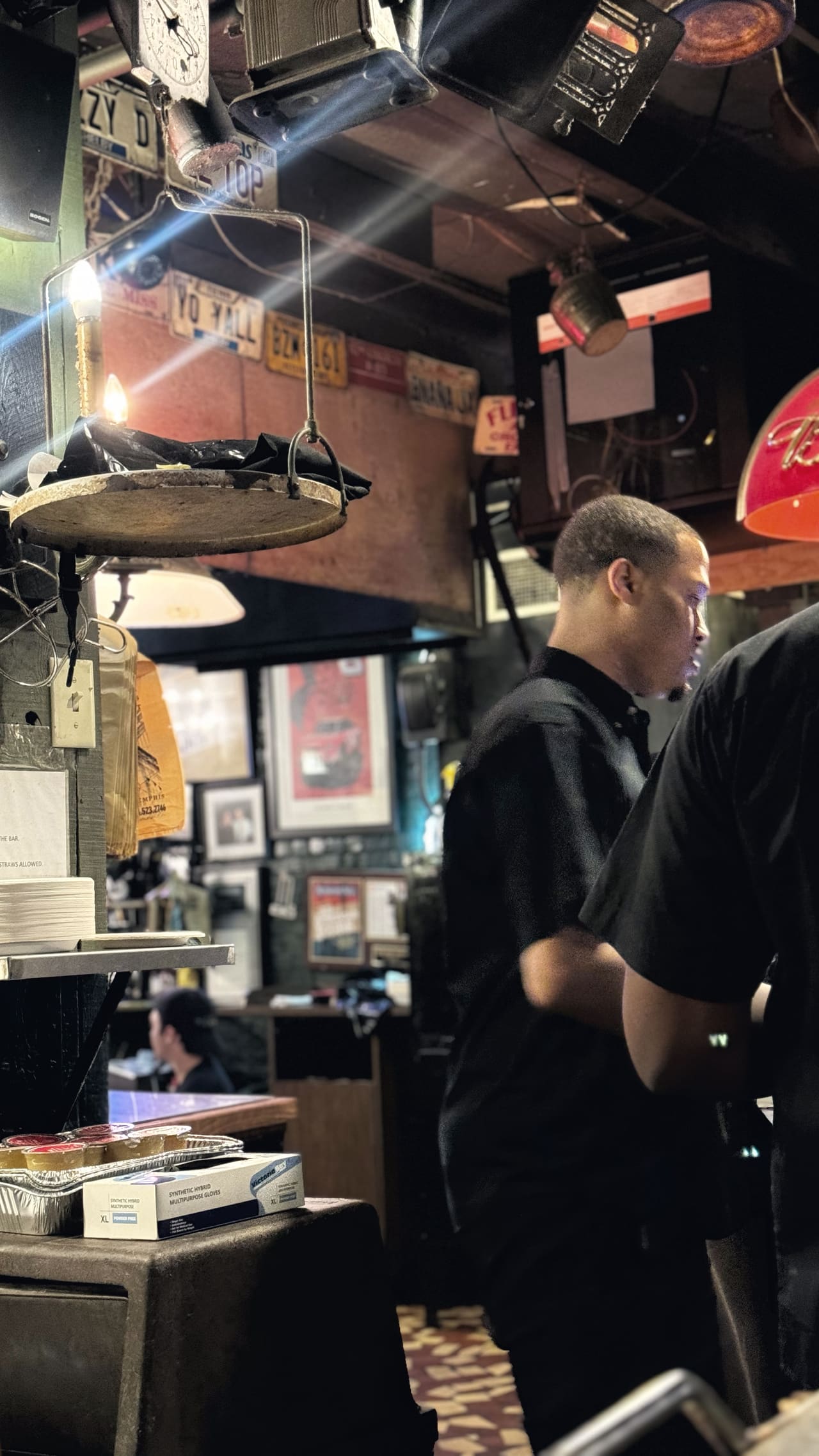 Inside a rib house — licence plates nailed across the wall, a brass scale hanging over the pass, a waiter in black